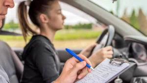 Driving examiner observing learner driver during practical driving test on road