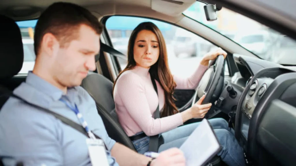 Learner driver receiving feedback after failing a driving test from examiner inside car
