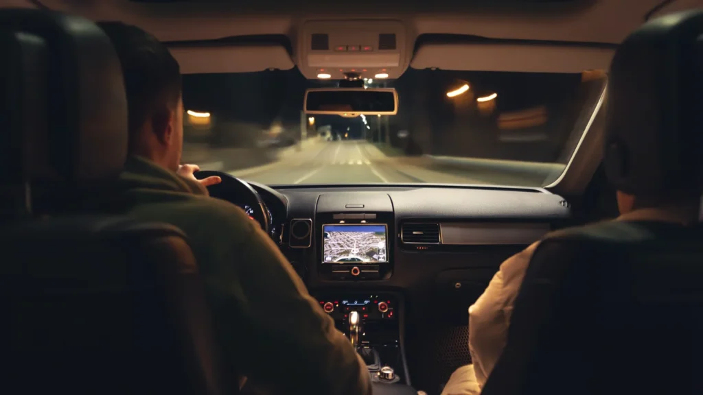 Driver safely traveling on a United States highway at night using headlights and maintaining a safe following distance.