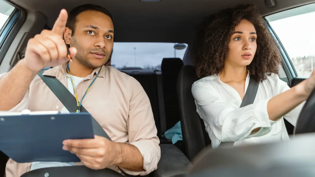 Driving Instructor Teaching Young Woman in Car