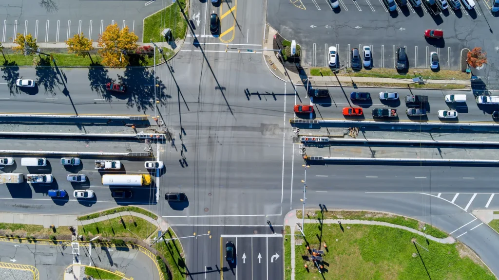 Four-way stop intersection in the United States showing vehicles waiting at stop signs and following right of way rules.