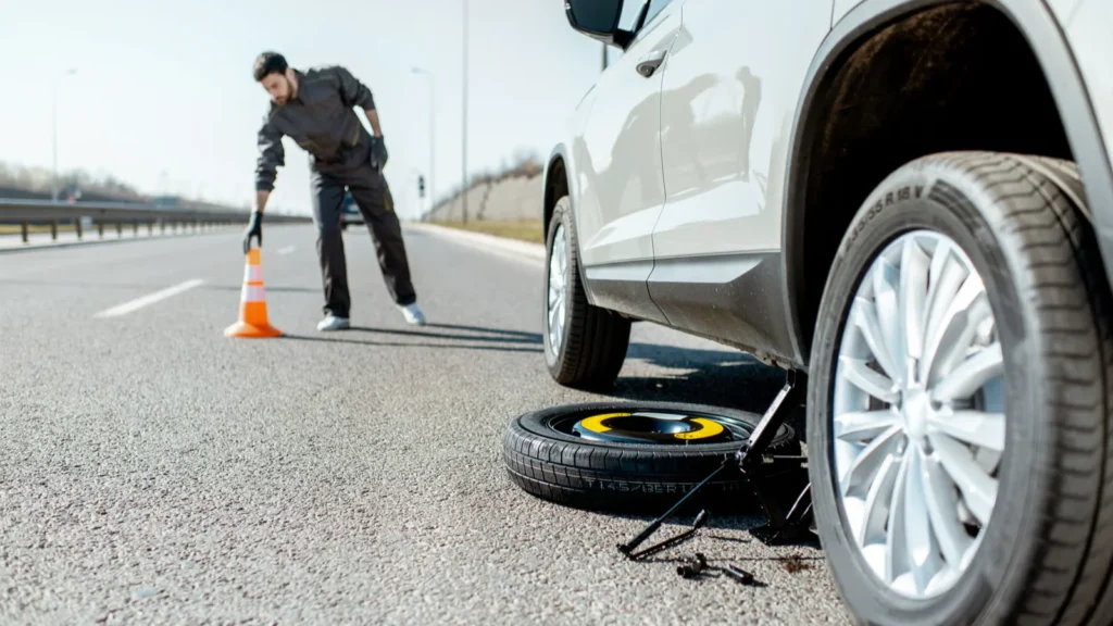 Man Changing Tire on Roadside Emergency