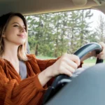 woman sitting on a driver place and hold a steering wheel